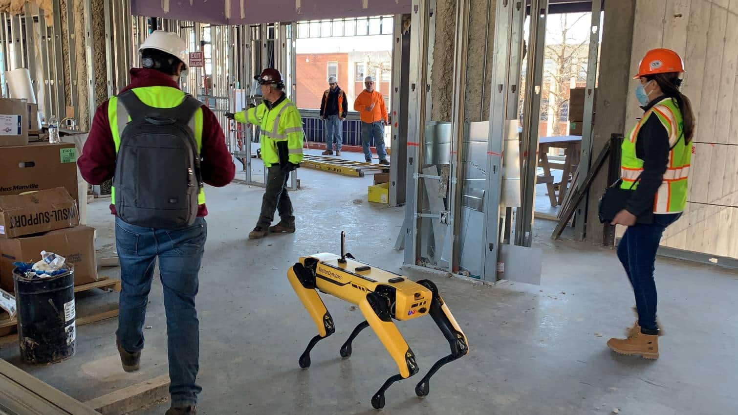 Spot with a 360° camera alongside workers on a construction site